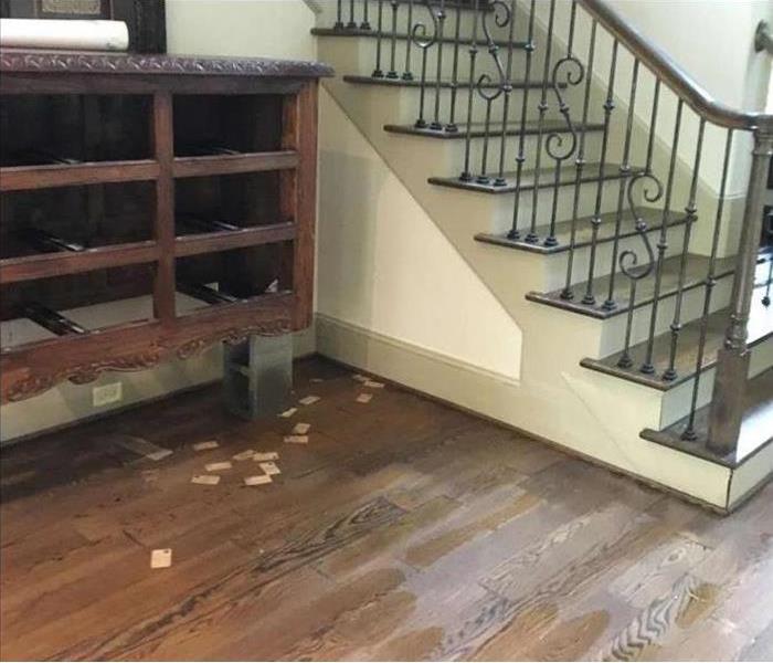 warped flooring, soaked walls by staircase