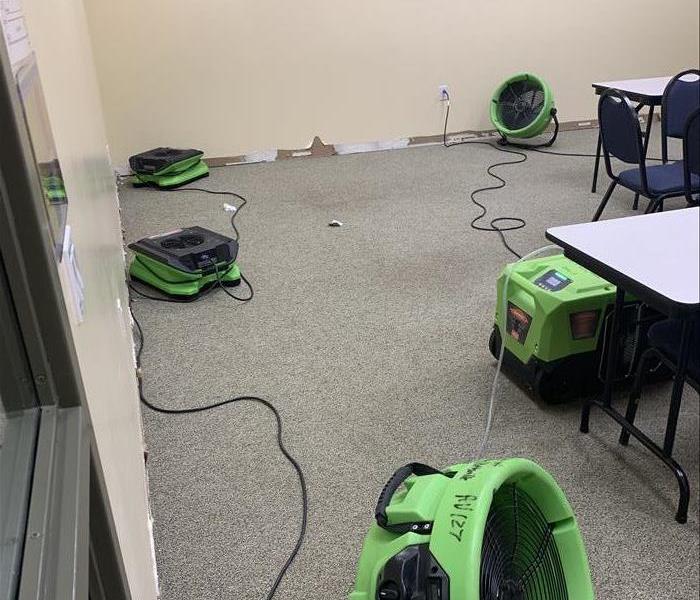 green equipment drying carpet and walls, the table showing